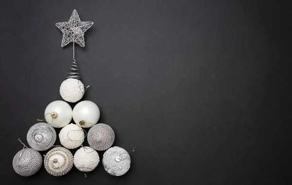 Vánoční ozdoby ve tvaru stromu na šedém černém pozadí, horní pohled — Stock fotografie