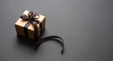 Siyah arka planda siyah kurdeleli hediye kutusu, Kara Cuma konsepti.