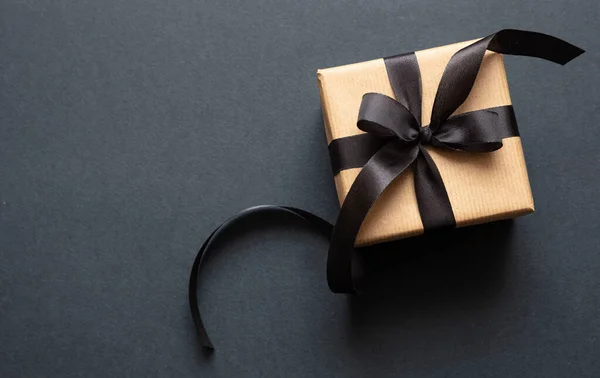 Geschenkbox mit schwarzem Band vor schwarzem Hintergrund, Black Friday Konzept. — Stockfoto