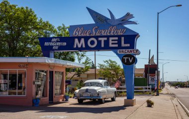 Otoyol 66 'nın yanındaki Mavi Kırlangıç Oteli ve girişe park edilmiş antika bir araba. Tucumcari, New Mexico, ABD.