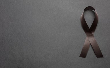 Siyah renkli arka planda siyah farkındalık kurdelesi. Melanoma ve keder kavramı