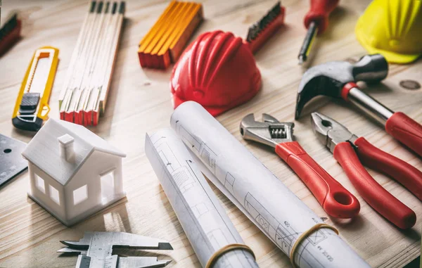 Herramientas, sombreros y planos de proyecto en escritorio de madera — Foto de Stock