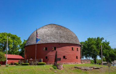 Kırmızı meşe tahtaları ve gri çatılı Arcadia yuvarlak ahırı, 66. yolun yanında bir dönüm noktasıdır. Arcadia, Oklahoma, ABD.