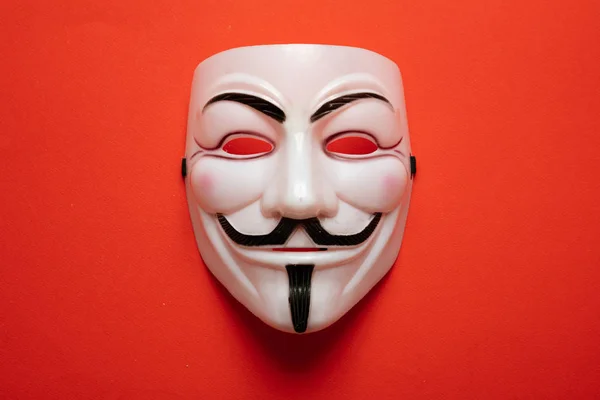 Anonymous mask against red background, closeup view — Stock Photo, Image