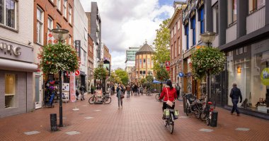 Eindhoven şehir merkezinde, dükkanlarla dolu bir sokakta yürüyen insanlar. Hollanda