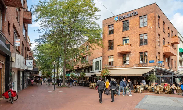 Emberek sétálnak vagy ülnek kávézókban és éttermekben, Eindhoven belvárosában. Egyesült Királyság — Stock Fotó