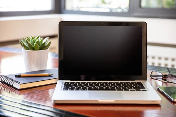 Laptop med svart tom skärm på ett träbord — Stockfoto