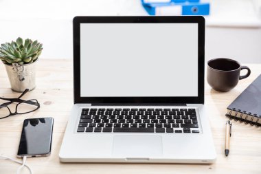 Ahşap bir masanın üstünde beyaz beyaz ekranlı bir laptop.