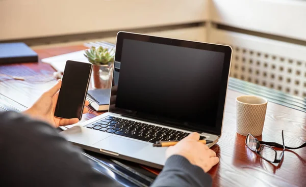 Laptop och smartphone med svarta tomma skärmar, kontor interiör bakgrund — Stockfoto