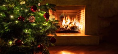 Noel ağacı, yanan şömine arkaplanına yakın.