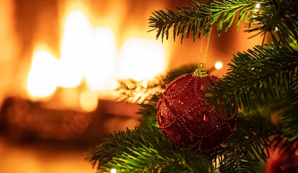 クリスマスツリーはぼやけた暖炉の背景で閉じます — ストック写真