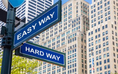 Easy way, hard way crossroads street sign. Highrise buildings background,