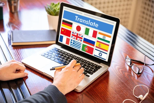 Человек, работающий на ноутбуке со словом перевести на экран компьютера — стоковое фото
