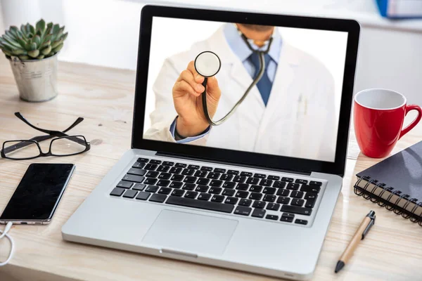 Telemedicine concept. Doctor GP on a computer screen, office desk background — Stock Photo, Image