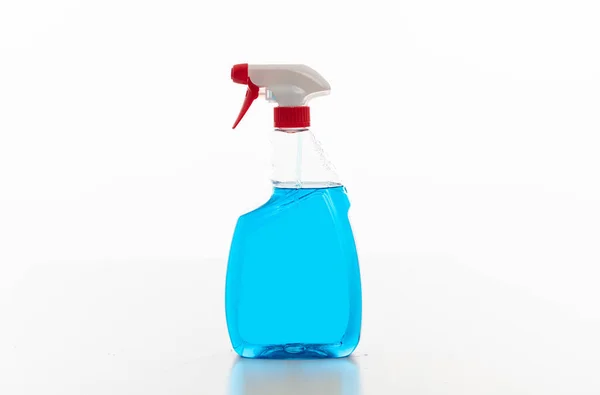 Butelka z sprayem czyszczącym przezroczysta z niebieskim płynem koloru izolowanym na białym tle. — Zdjęcie stockowe
