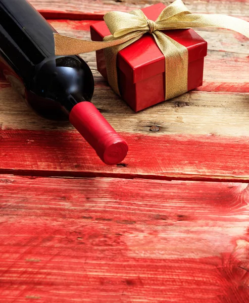 Dia dos Namorados. Garrafa de vinho tinto e um presente em madeira — Fotografia de Stock