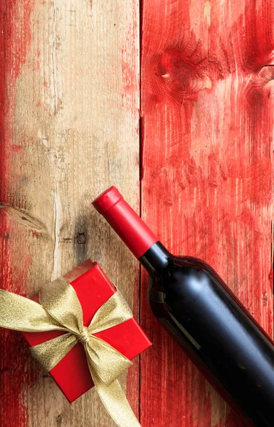 Saint Valentin. Bouteille de vin rouge et cadeau sur bois — Photo