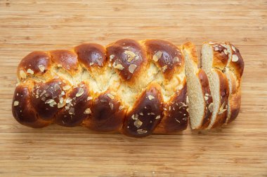 Tatlı ekmek, paskalya tsoureki cozonac dilimlenmiş ahşap masa arka planı, üst manzara. Örülmüş brioş, geleneksel şenlikli challah