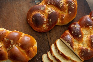 Tatlı ekmek, paskalya tsoureki cozonac dilimlenmiş ahşap masa arka planı, üst manzara. Örülmüş brioş, geleneksel şenlikli challah