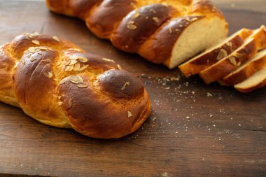 Tatlı ekmek, paskalya tsoureki cozonac, ahşap masa arka planında dilimlenmiş, yakın görüş. Örülmüş brioş, geleneksel şenlikli challah