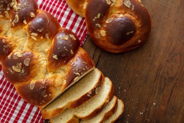 Tatlı ekmek, paskalya tsoureki cozonac dilimlenmiş ahşap masa arka planı, üst manzara. Örülmüş brioş, geleneksel şenlikli challah