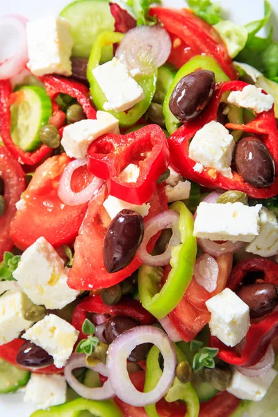 Greek salad background texture. Fresh vegetables tomato and cucumber salad with feta cheese, herbs and olive oil. Traditional healthy greek cuisine