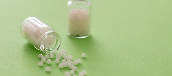 Homöopathie Konzept Homöopathische Kügelchen Aus Einer Glasflasche Grüner Hintergrund Alternative — Stockfoto