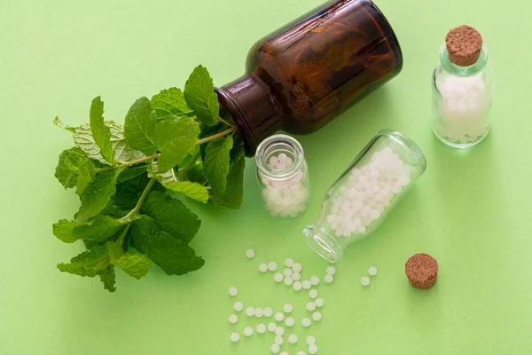 Conceito Homeopatia Glóbulos Homeopáticos Frasco Vidro Erva Fresca Fundo Verde — Fotografia de Stock