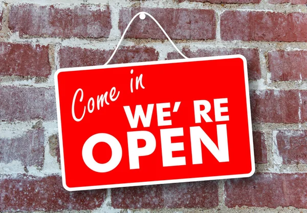 Open come in store sign. Red color sign board, Come in we re open text hanging on brick wall background