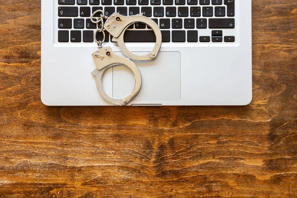 Kajdanki Laptopie Drewniane Biurko Widok Góry Cyberprzestępczość Koncepcja Aresztowania Hakerów — Zdjęcie stockowe