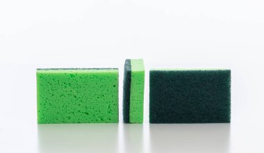 Beyaz arka planda izole edilmiş mutfak süngerleri. Bulaşık yıkamak için yeşil renkli süngerler, ev malzemeleri