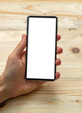 Cep telefonu ekran modeli. Beyaz ekranlı akıllı telefon tutan adam, tahta arka plan, boşluğu kopyala