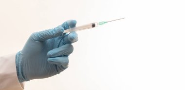 - İlaç aşısı. Doktor eli aşıyı beyaz arka planda izole edilmiş, yakın plan şırıngayla enjekte ediyor. Hastane konseptinde sağlık hizmeti.
