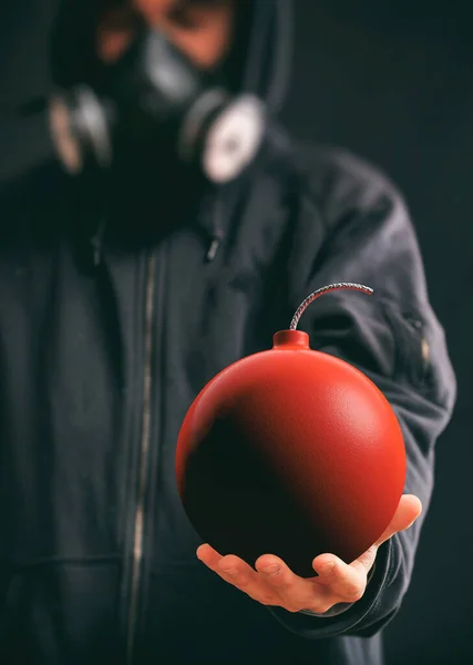 Человек Капюшоне Респираторной Маске Держит Красную Бомбу Черном Фоне Концепция — стоковое фото