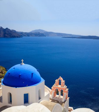 Santorini Adası, Yunanistan. Mavi kubbeli beyaz ortodoks kilisesi mavi sakin deniz ve berrak gökyüzü arka planı, Oia köyü