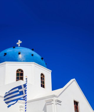 Santorini Adası, Yunanistan. Mavi kubbeli beyaz ortodoks kilisesinde mavi berrak arkaplan, dikey fotoğraf