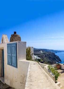 Santorini Adası, Yunanistan. Geleneksel mimari, ev girişi, teras ve kaldera manzarası Ege Denizi üzerinde, mavi berrak gökyüzü, durgun deniz