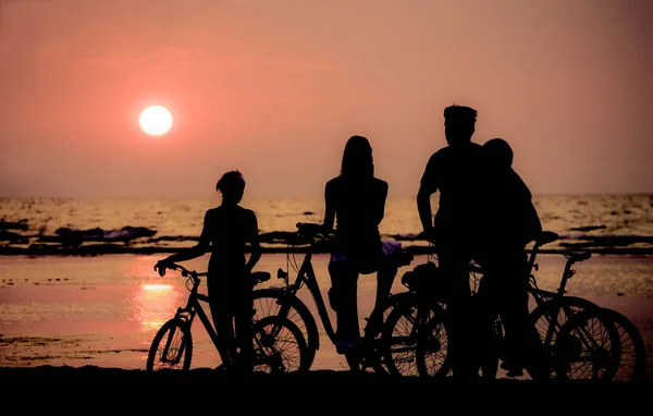 Family rest on bicycles. Sunset. Contours.