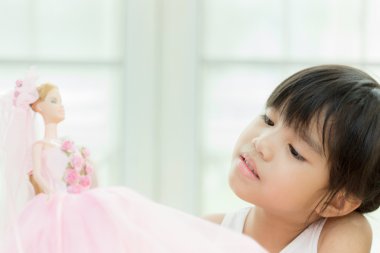 evde bebekle oynarken sevimli küçük kız