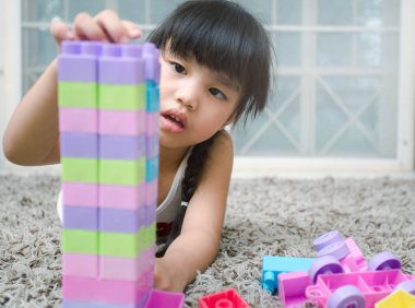 Mutlu küçük kız bir kule inşa inşaat oyuncak bloklarla oynama. Oynayan çocuklar. Çocuk ve oyuncaklar