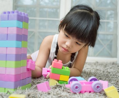 Mutlu küçük kız bir kule inşa inşaat oyuncak bloklarla oynama. Oynayan çocuklar. Çocuk ve oyuncaklar
