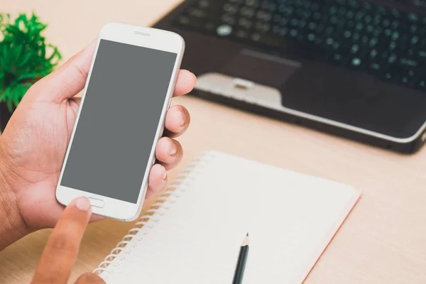 Affärsmannens händer innehav och användning mobiltelefon på på office bord — Stockfoto