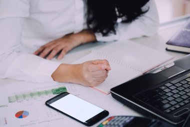 Ofis iç PC smartphone tutarak çalışan kadın. Cep telefonu ve dizüstü bilgisayar kullanan office kişi