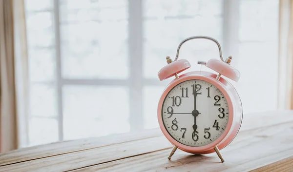 Clock on wood in the morning, blurred living room background