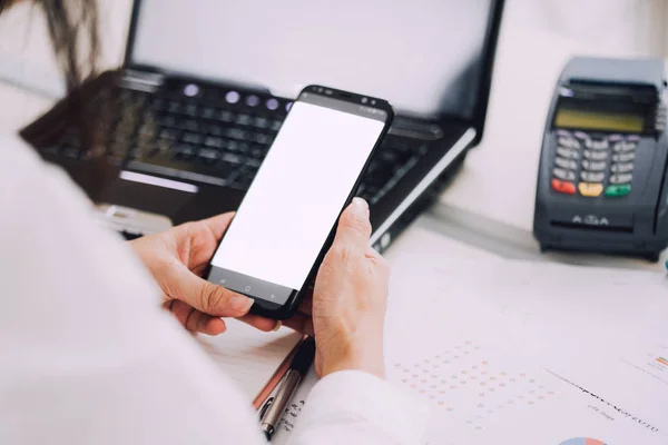 Wanita yang bekerja di interior kantor pada pc memegang smartphone.Office orang menggunakan ponsel dan laptop — Stok Foto