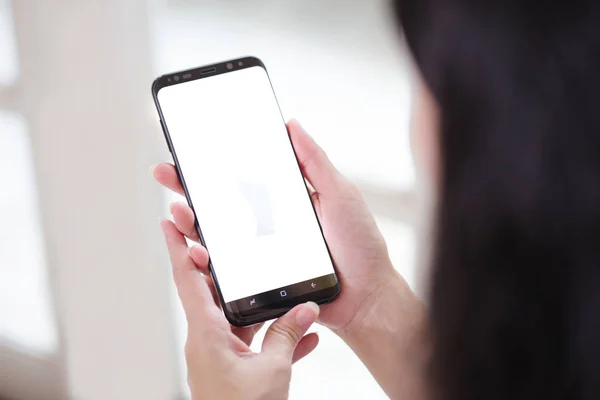 Wanita yang bekerja di interior kantor pada pc memegang smartphone.Office orang menggunakan ponsel dan laptop — Stok Foto