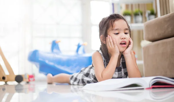 Carino asiatico ragazza lettura un libro mentre in il live stanza . — Foto Stock