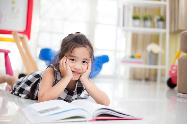 Carino asiatico ragazza lettura un libro mentre in il live stanza . — Foto Stock