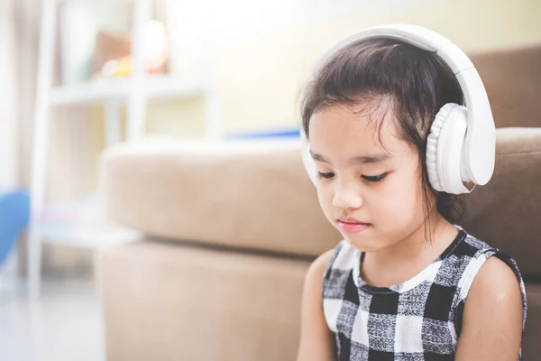 Szczęśliwa dziewczyna azjatyckich za pomocą słuchawki słuchać muzyki przez smartfon w sali na żywo — Zdjęcie stockowe