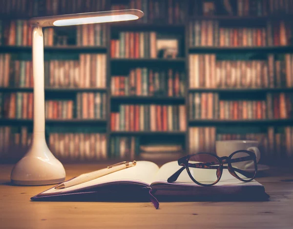 Schreibtisch mit LED-Lampe, Tasse Kaffee und Papierstapel — Stockfoto